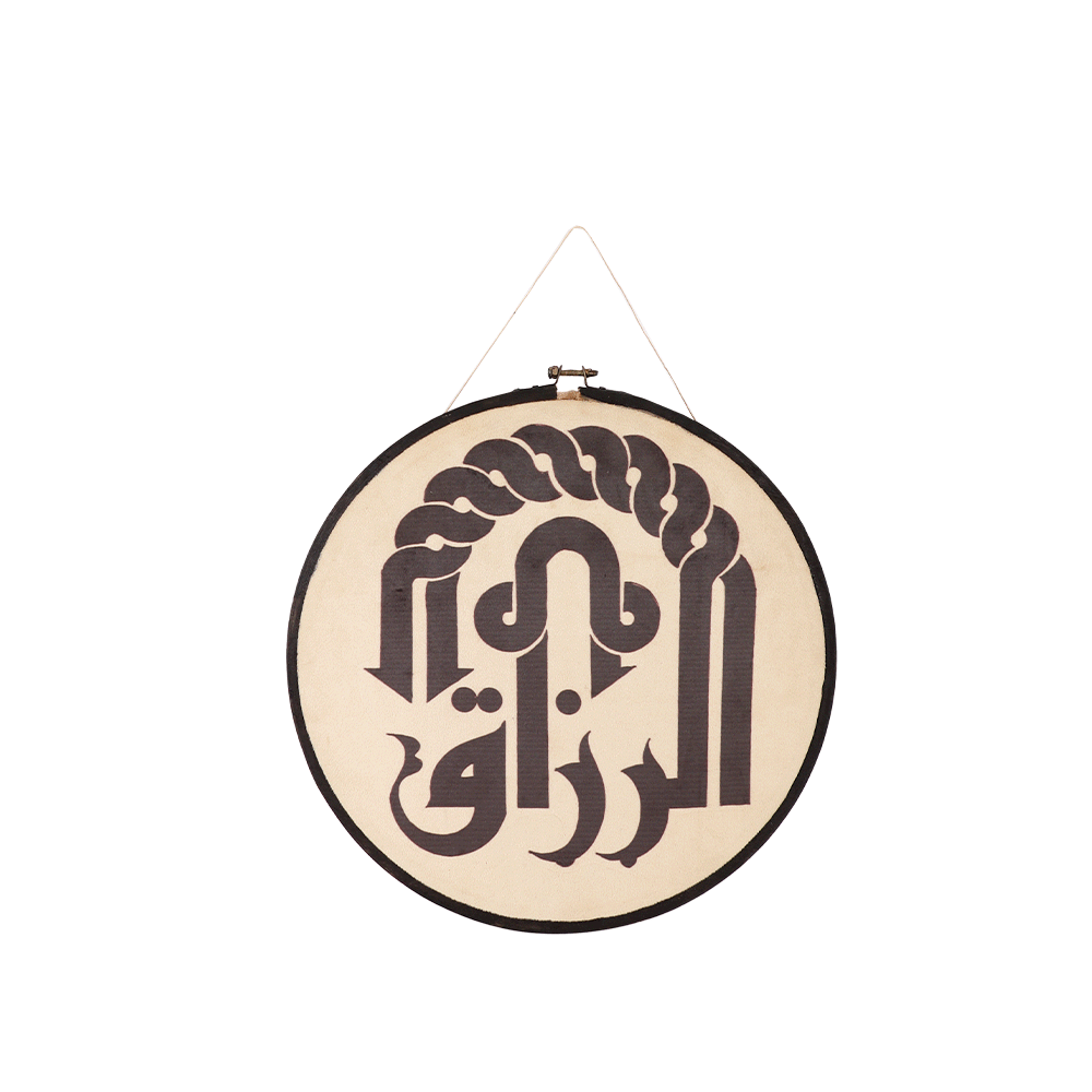 لوحة دائرية من بصمات قماشية على إطار خشبي بعبارة الرزّاق بطباعة حرارية